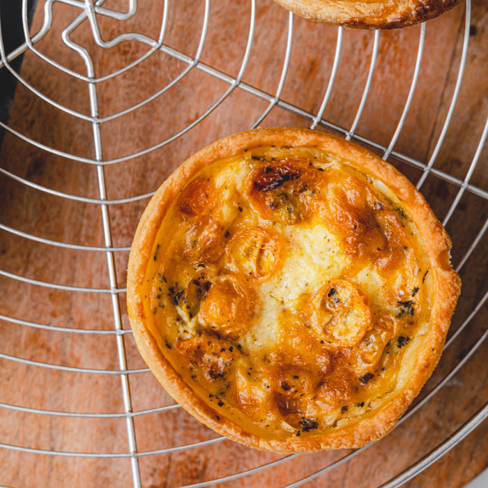 A small gluten-free quiche lorraine on a cooling rack