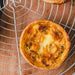 A small gluten-free quiche lorraine on a cooling rack