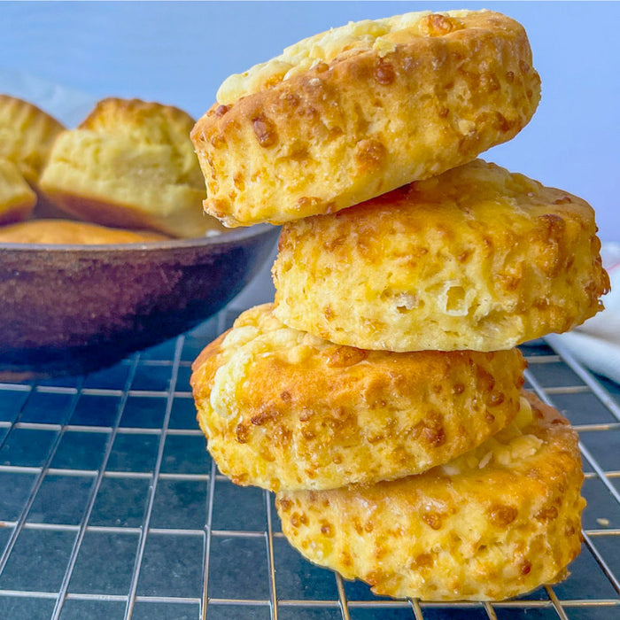 Four gluten free cheese scones stacked on a cooling rack
