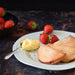 Strawberry pasties layered on a plate with cream and strawberries.