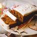 Gluten free large Christmas cake, sliced on a white plate. Suitable for vegans.